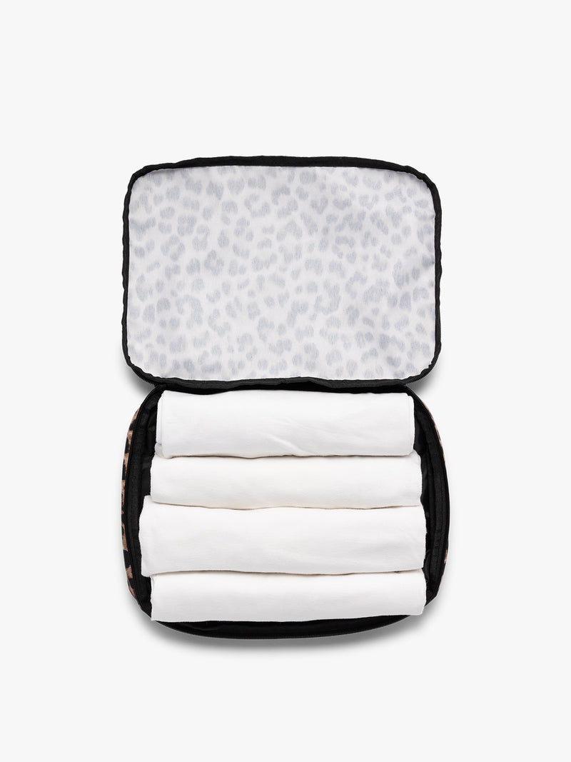 Opened view of a tan and black animal print Leopard CALPAK Medium Compression Packing Cubes with zippers shown on a clean white background