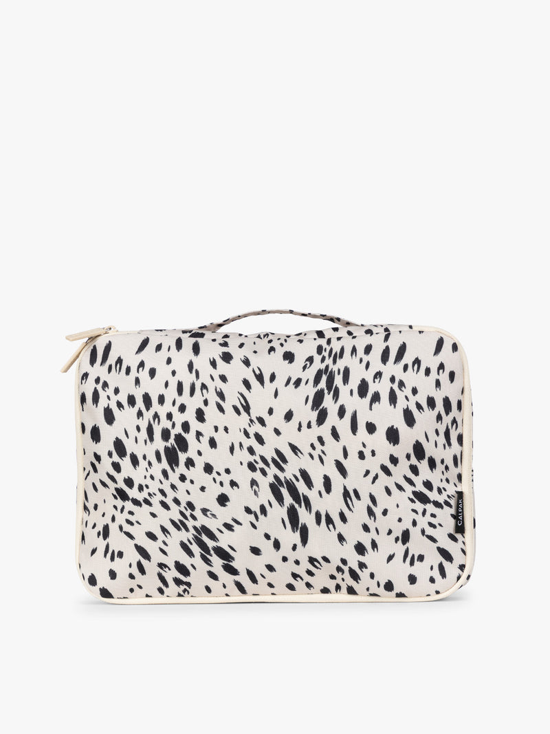 Close up of white and black animal print Snow Leopard CALPAK Medium Compression Packing Cubes with zippers shown on a clean white background