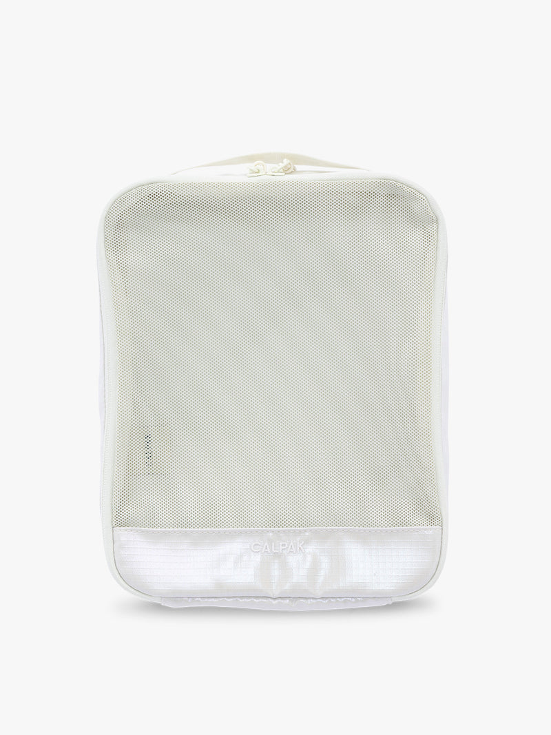 Medium size packing cube of the CALPAK Terra 5-Piece Packing Cube Set in shiny white iridescent Moonbeam with two small cubes, two medium cubes, and one large mesh cube with zippers and mesh