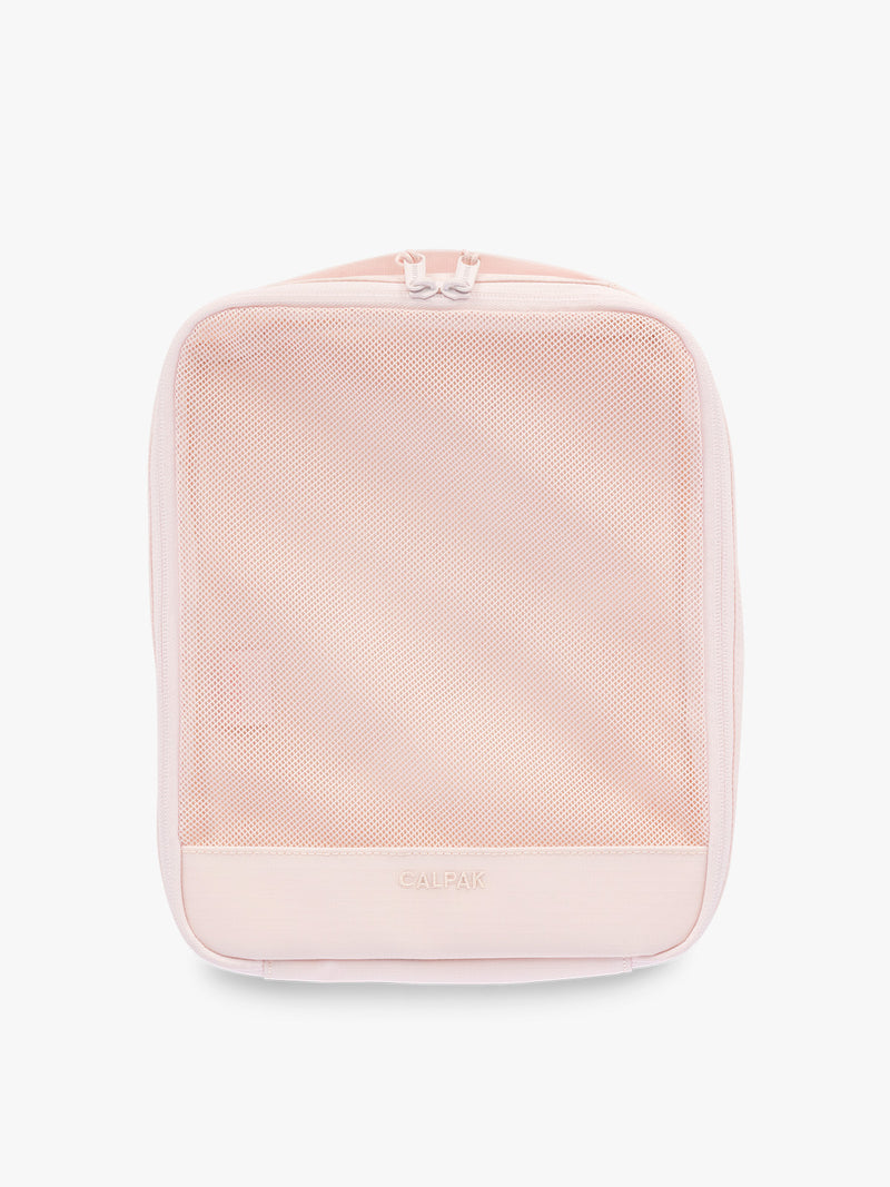 Medium size packing cube of CALPAK Terra 5-Piece Packing Cube Set in pink Shell Pink with two small cubes, two medium cubes, and one large mesh cube with zippers and mesh