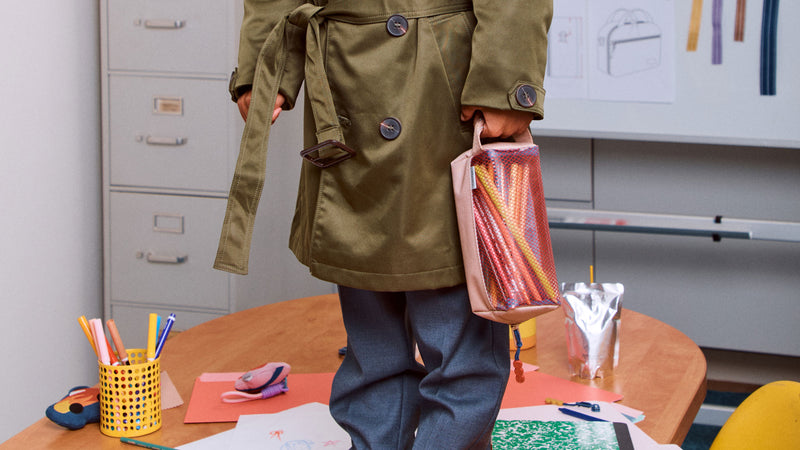 CALPAK Kids Collection filled with colored pencils in tan Khaki being held by child