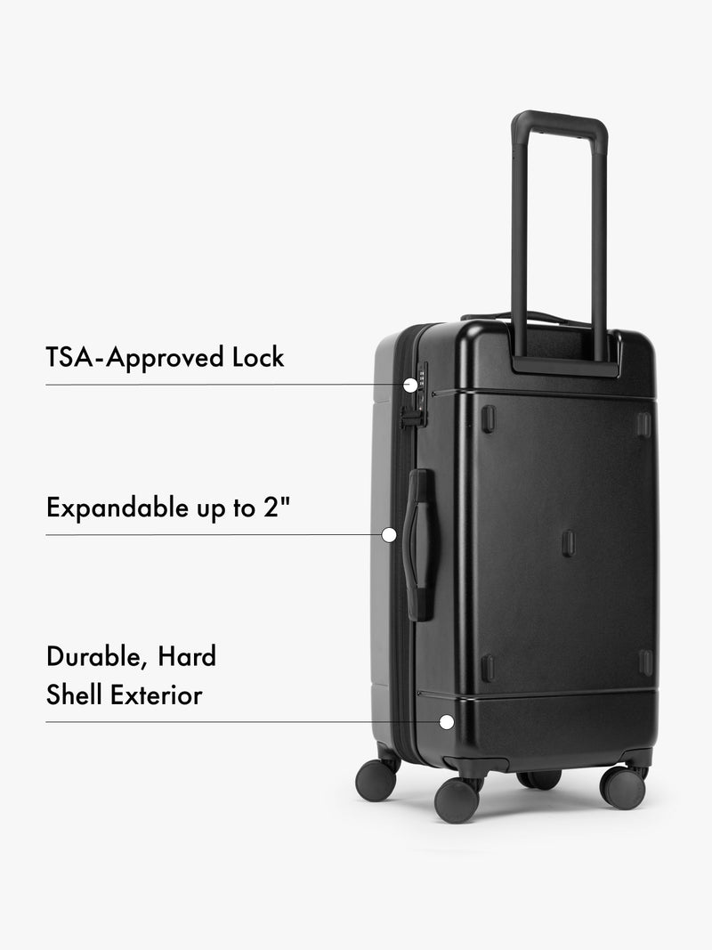 CALPAK Black medium suitcase with features highlighted on a white background