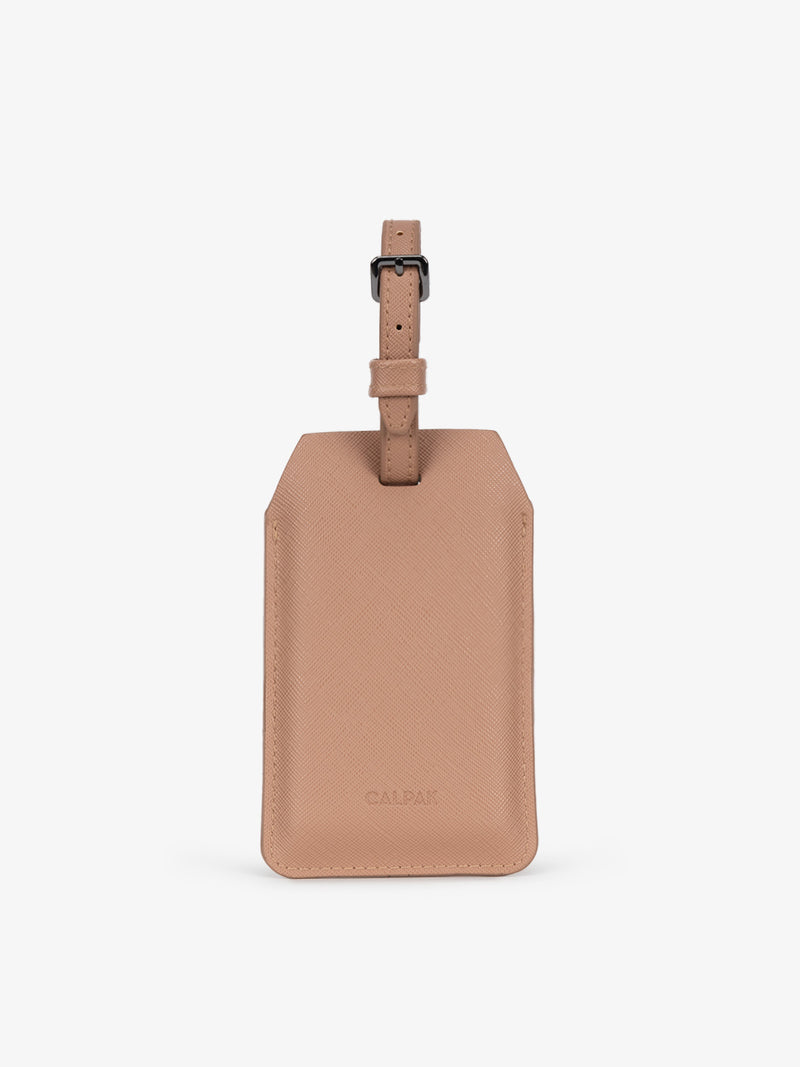 The Portable Luggage Tag Charger in brown, shown attached to a suitcase and charging an iPhone in a lifestyle setting