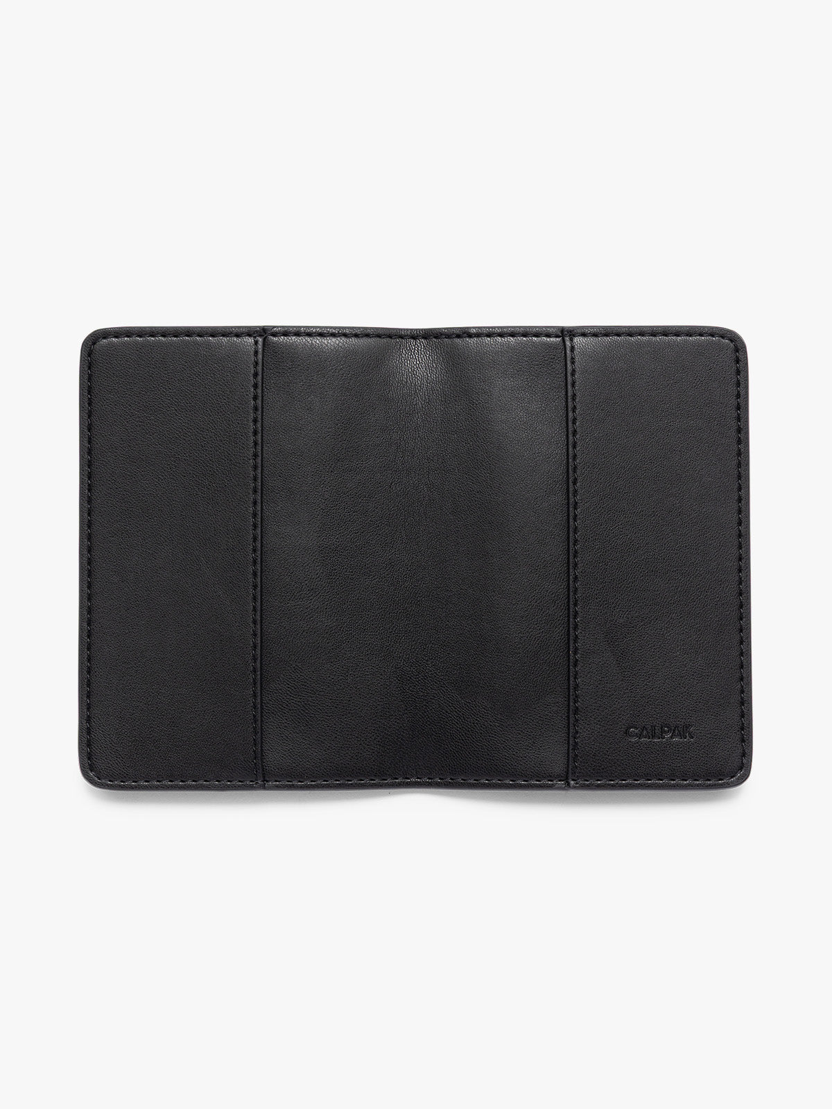 A black CALPAK passport HOLDER shown open against a plain white background, featuring the brand name 'CALPAK' debossed on the bottom right PWTS2601-BLACK