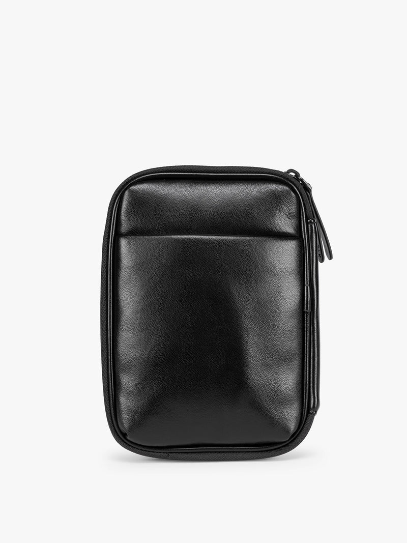 Backside of a  Black CALPAK Luka Zip Passport Wallet in vegan leather with a zippered top and a front pocket, shown on a plain white background