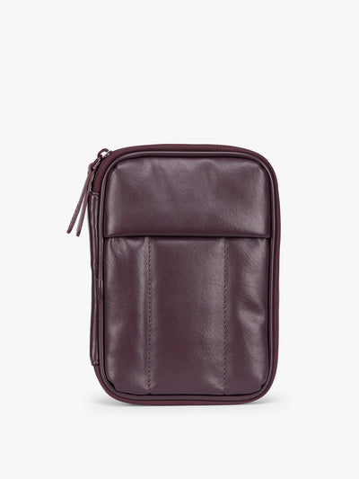 A deep burgundy Dark Cherry CALPAK Luka Zip Passport Wallet in vegan leather with a zippered top and a front pocket, shown on a plain white background; PZW2301-DARK-CHERRY-PU view 1