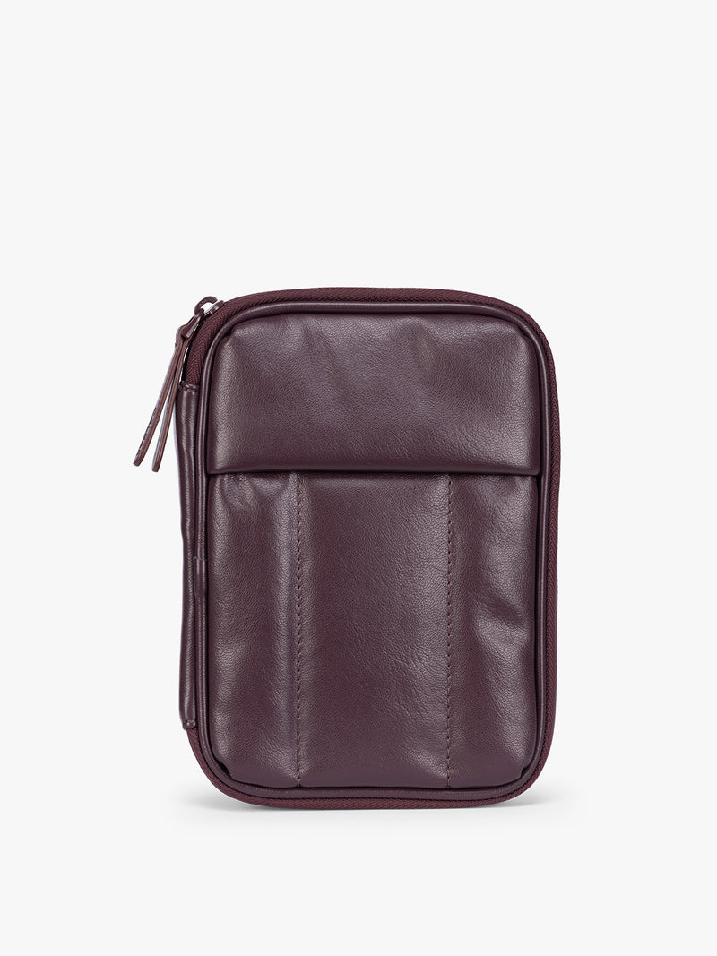 A deep burgundy Dark Cherry CALPAK Luka Zip Passport Wallet in vegan leather with a zippered top and a front pocket, shown on a plain white background