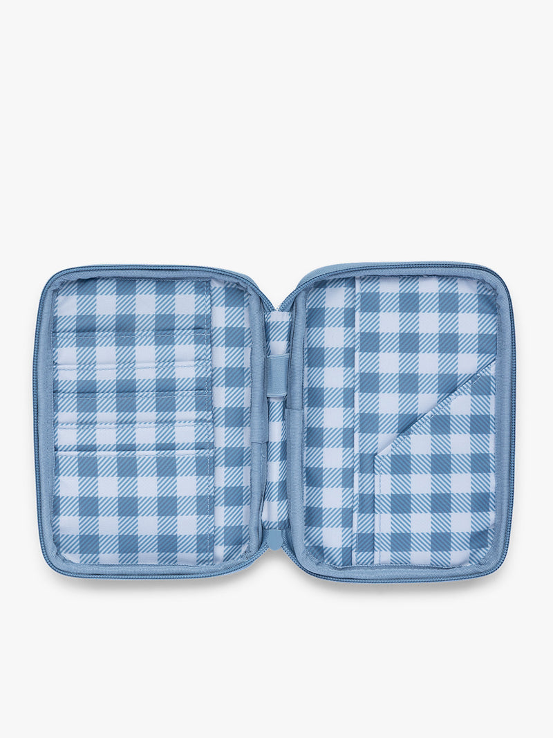 Opened view of the CALPAK Luka Zippered Passport Wallet in light blue French Blue with white and blue gingham interior