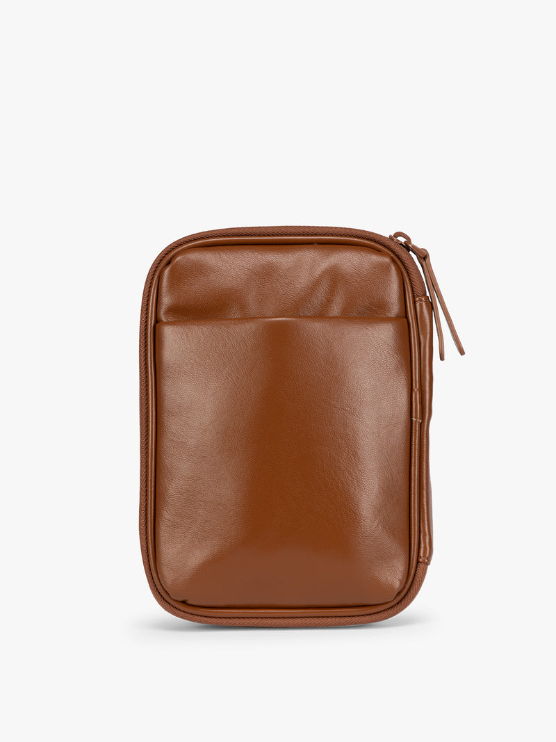 Backside of a light Honey Brown CALPAK Luka Zip Passport Wallet in vegan leather with a zippered top and a front pocket, shown on a plain white background