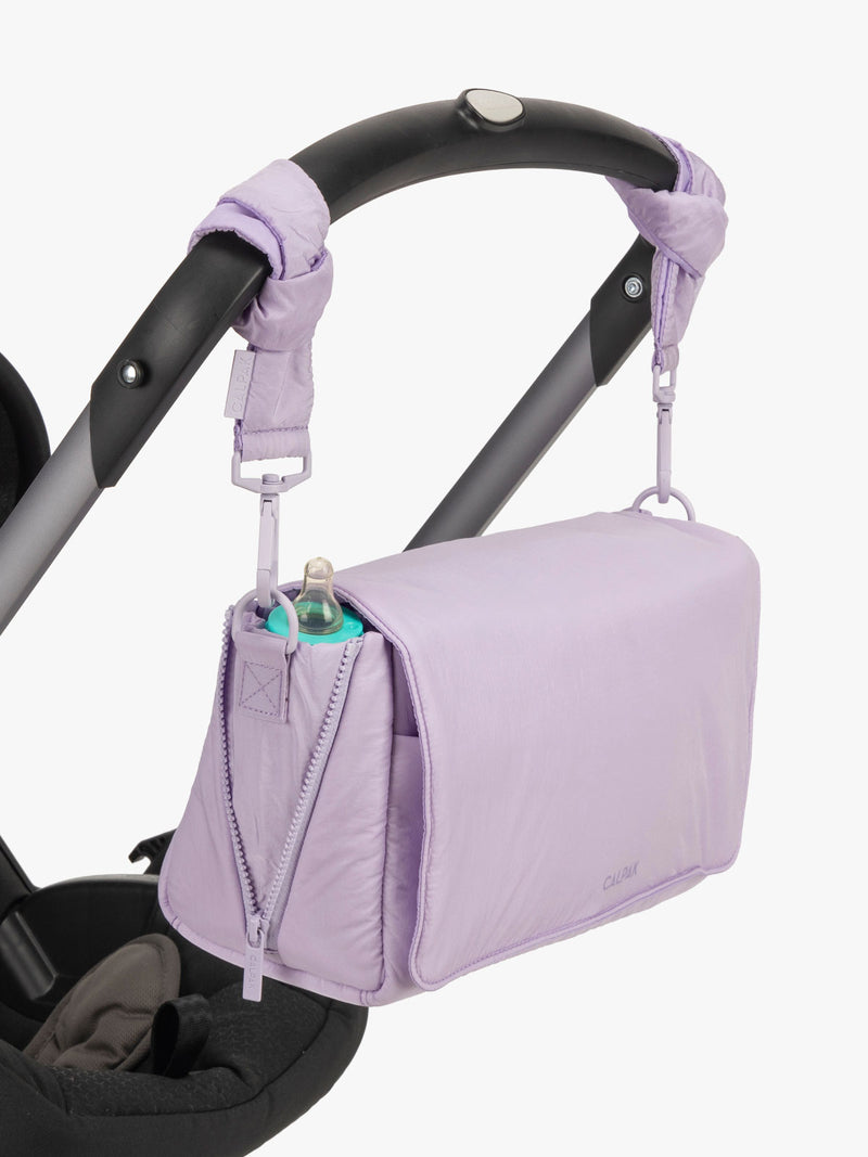 CALPAK Convertible Stroller Caddy Crossbody in lavender purple Orchid hanging on stroller with stroller straps