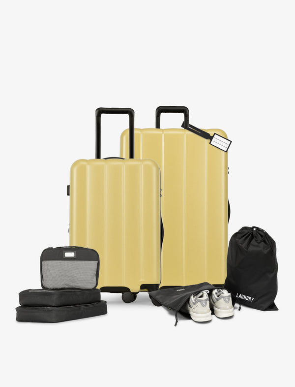 CALPAK starter bundle with carry-on, large luggage, packing cubes, pouches, and luggage tag in butter