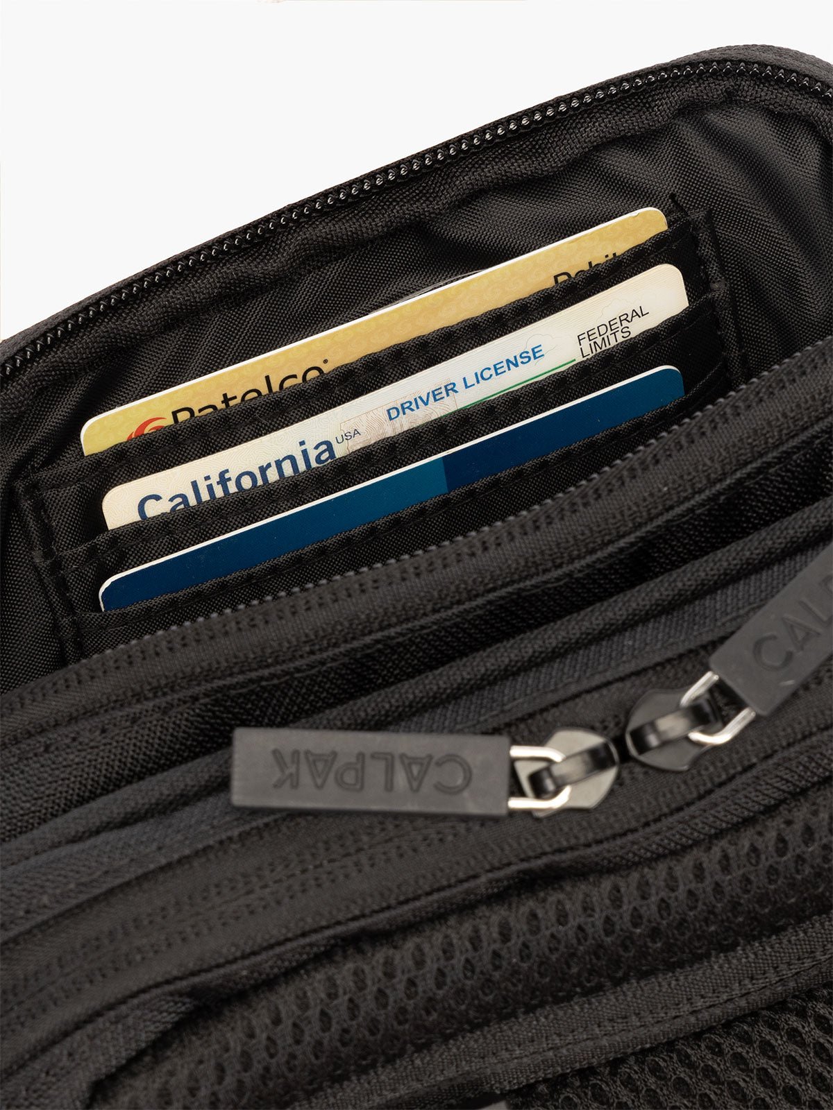 Interior view of CALPAK Stevyn Fanny Pack with secure, padded back zippered pocket and RFID protection in black