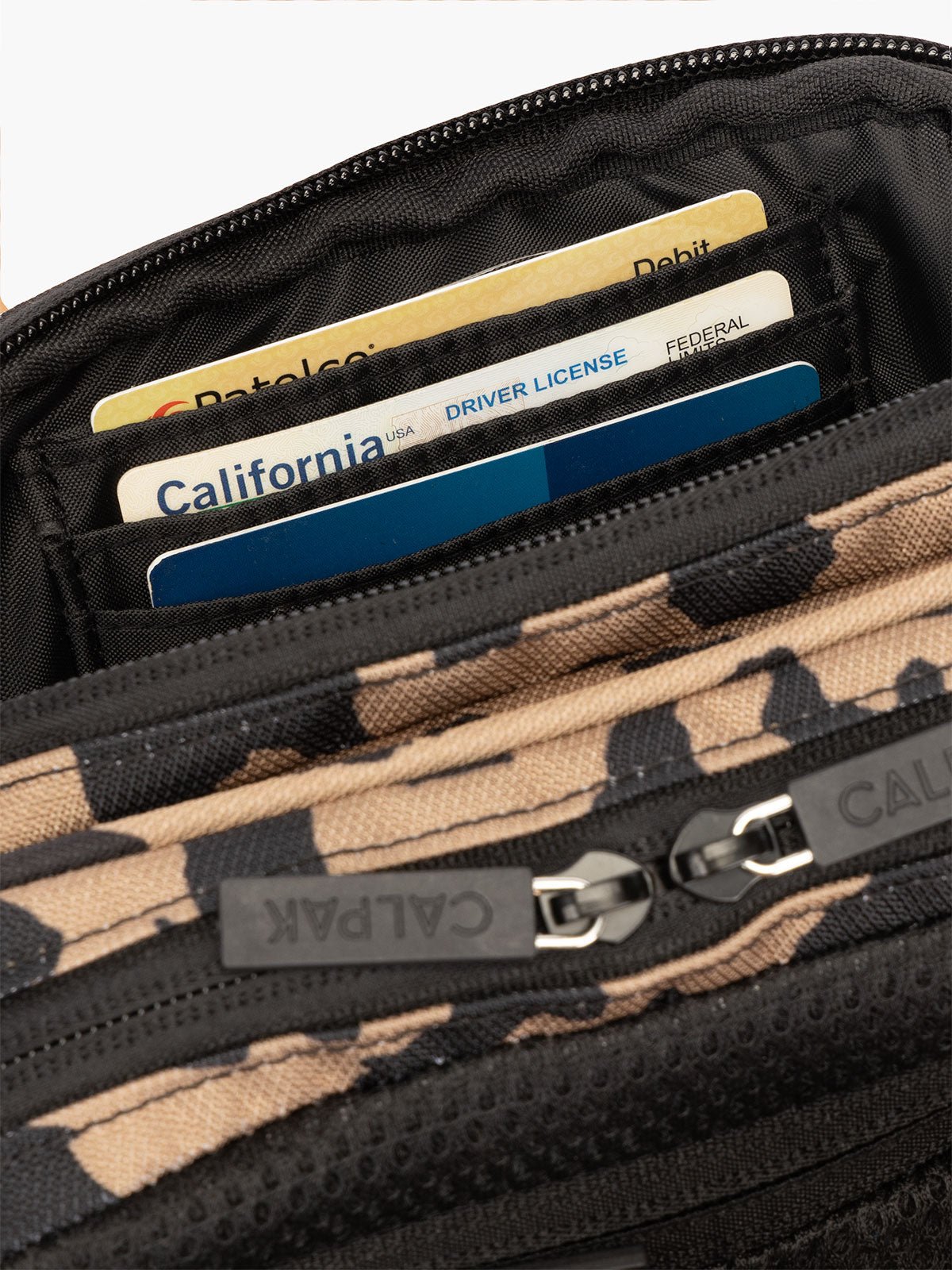 Interior view of CALPAK Stevyn Fanny Pack with secure, padded back zippered pocket and RFID protection in cheetah print