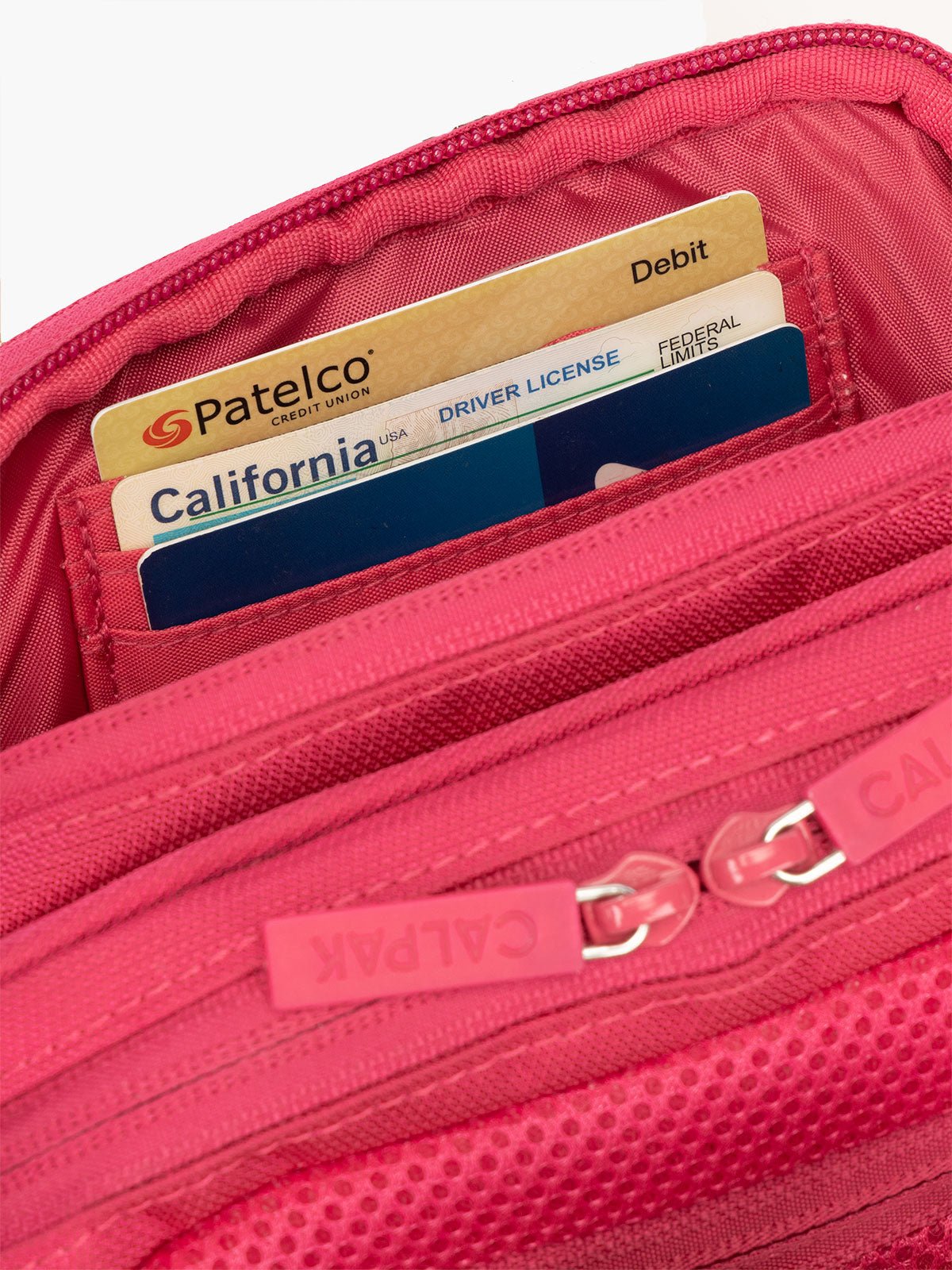 Interior view of CALPAK Stevyn Fanny Pack with secure, padded back zippered pocket and RFID protection in dragonfruit