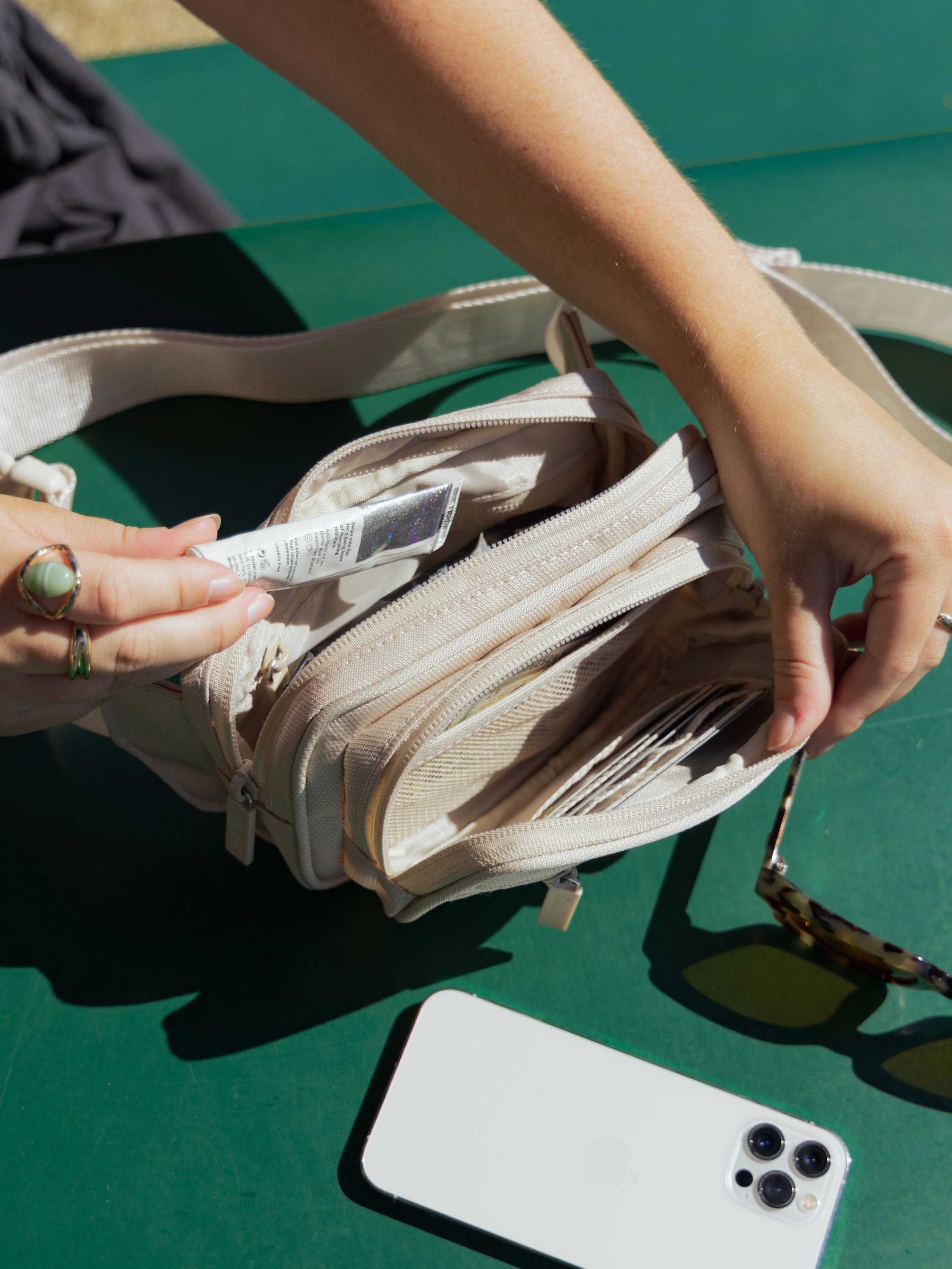 Model displaying interior view of CALPAK fanny pack in ivory dune