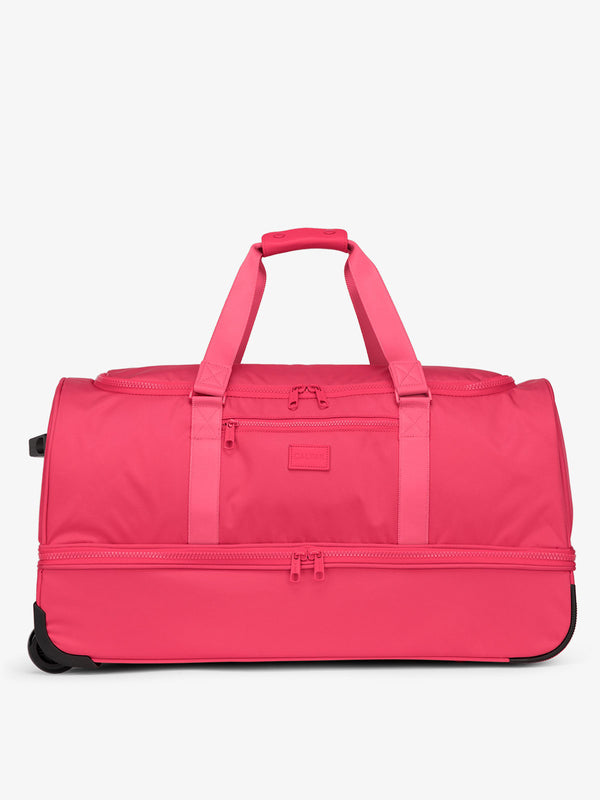 Hot pink CALPAK large rolling duffel bag featuring dual handles, zipper enclosed compartments, and shoe compartment