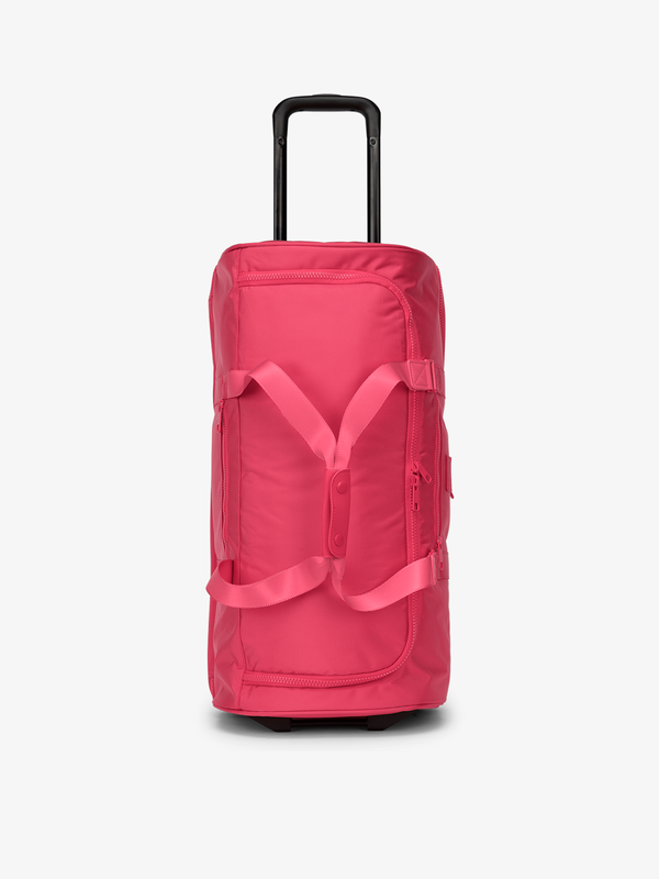 CALPAK large rolling duffel bag with wheels featuring fully extended top handle in pink