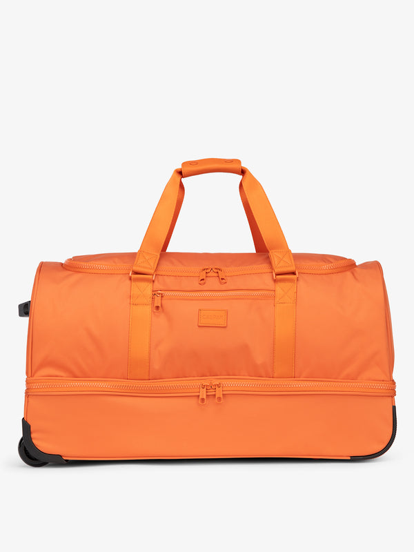 CALPAK large rolling duffel bag featuring dual handles, zipper enclosed compartments, and shoe compartment in orange