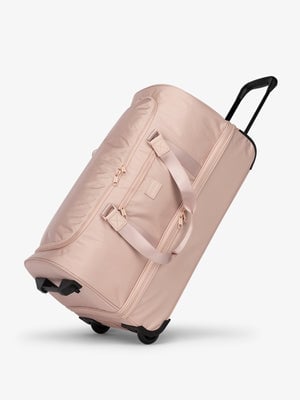 Side view of CALPAK Stevyn Large Rolling Duffel in pink sand; DRL2301-PINK-SAND