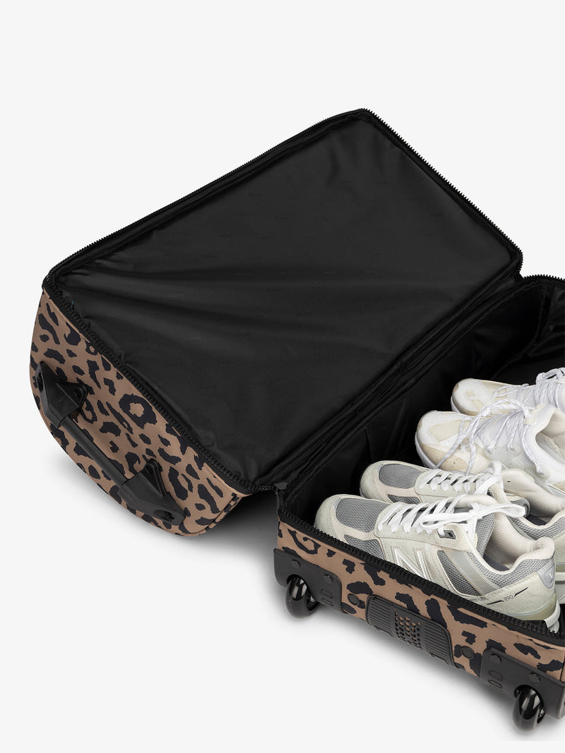 Interior view of shoe compartment in the CALPAK large rolling duffel bag in cheetah