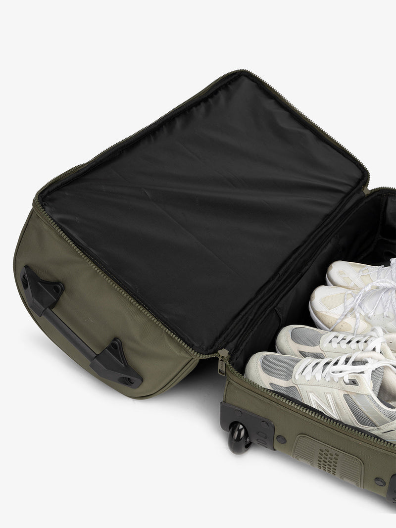 Interior view of CALPAK shoe compartment in the large rolling duffel bag in dark green moss