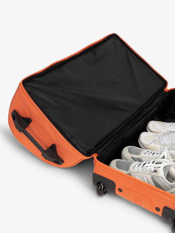 Large shoe compartment in the rolling travel duffel bag in orange