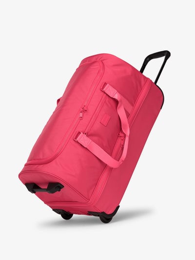 Side view of CALPAK Stevyn Large Rolling Duffel in dragonfruit pink; DRL2301-DRAGONFRUIT