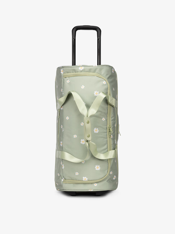 CALPAK large rolling duffel bag with wheels featuring fully extended top handle in green floral daisy