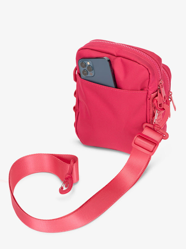 Back-view of CALPAK Stevyn Mini Crossbody Bag with detachable shoulder strap and back-slip pocket for cell phone or other belongings in pink dragonfruit