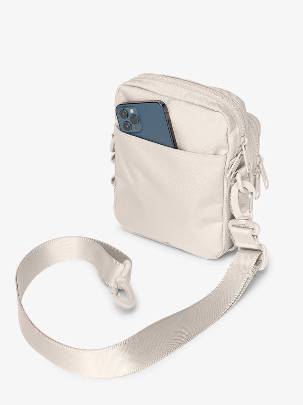 Back-view of ivory CALPAK Stevyn Mini Crossbody Bag with back-slip pocket for cell phone or other belongings