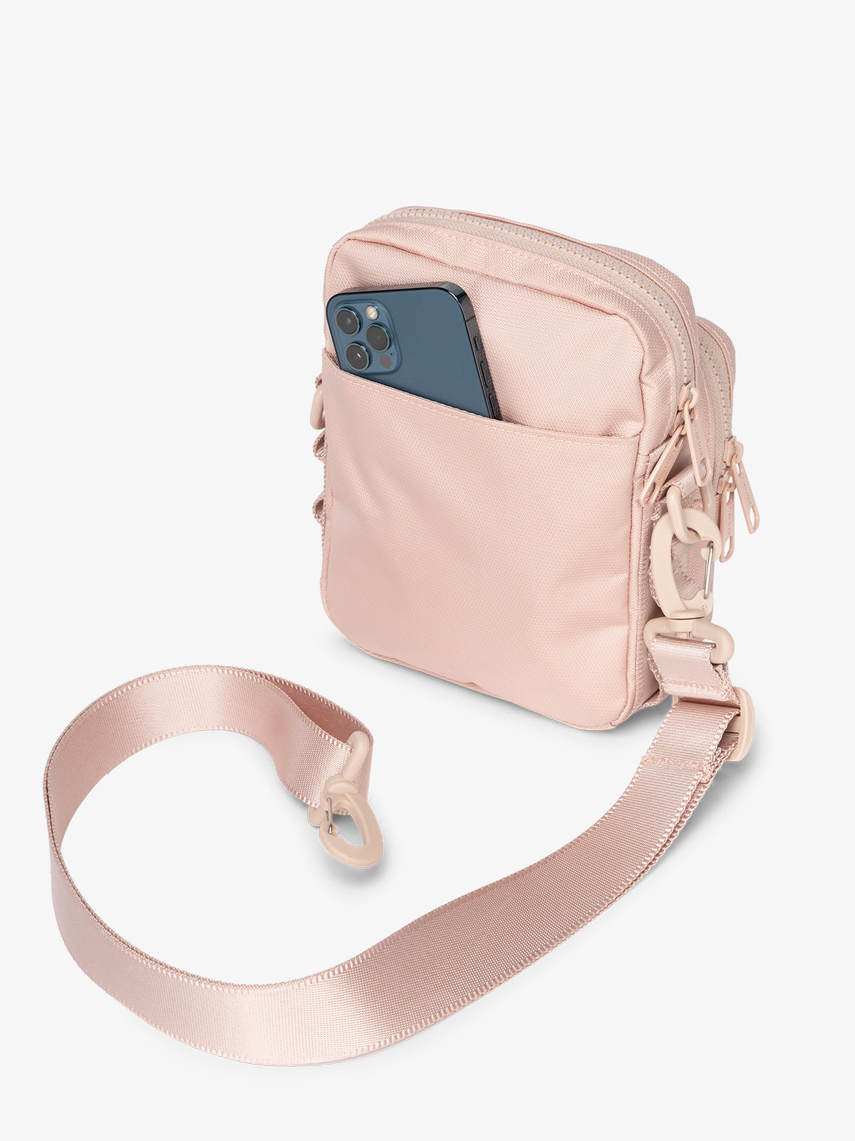 Back-view of pink sands CALPAK Stevyn Mini Crossbody Bag with detachable shoulder strap and back-slip pocket for cell phone or other belongings