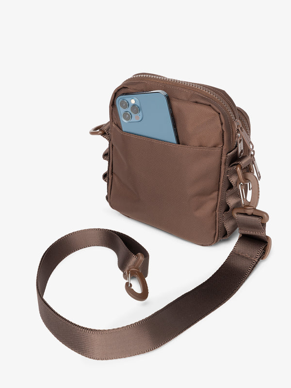 Back-view of CALPAK Stevyn Mini Crossbody Bag with detachable shoulder strap and back-slip pocket for cell phone or other belongings in walnut