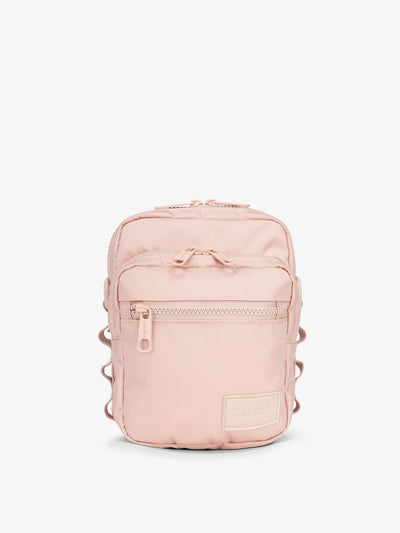 Front-view of CALPAK Stevyn Mini Crossbody Bag with zippered pockets and side panel daisy chains in pink sand; ACS2301-PINK-SAND