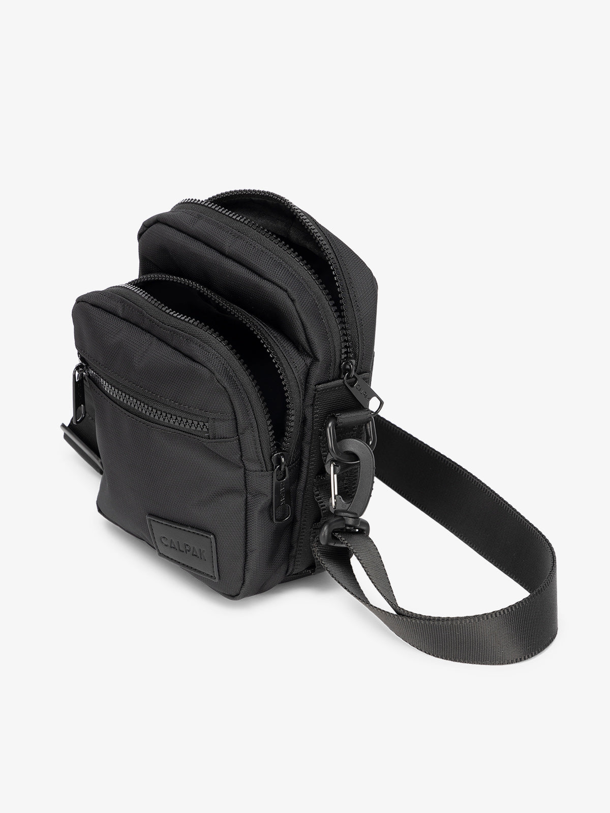 Black CALPAK Stevyn Mini Crossbody Bag with adjustable shoulder strap, zippered pockets, and interior zipper pocket