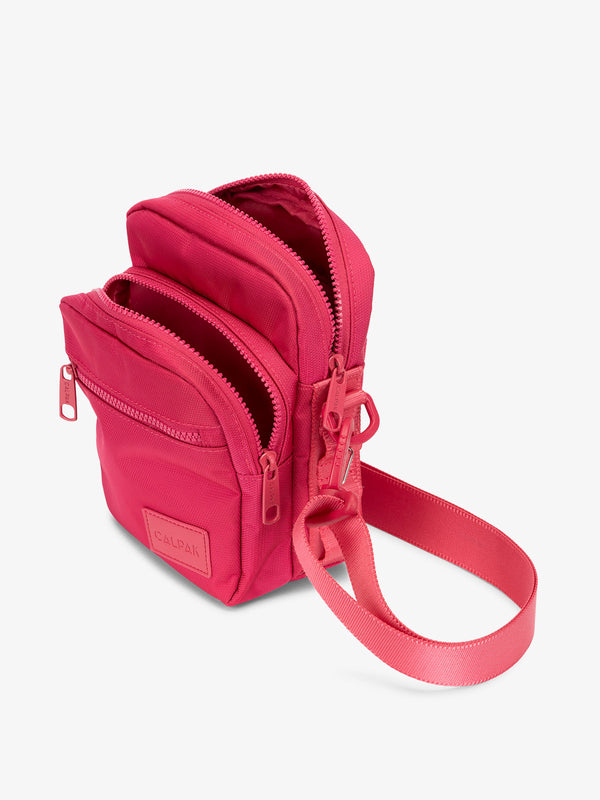 Hot pink CALPAK Stevyn Mini Crossbody Bag with adjustable shoulder strap, zippered pockets, and interior zipper pocket