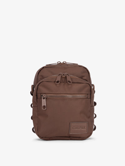Front-view of CALPAK Stevyn Mini Crossbody Bag with zippered pockets and side panel daisy chains in walnut; ACS2301-WALNUT view 1