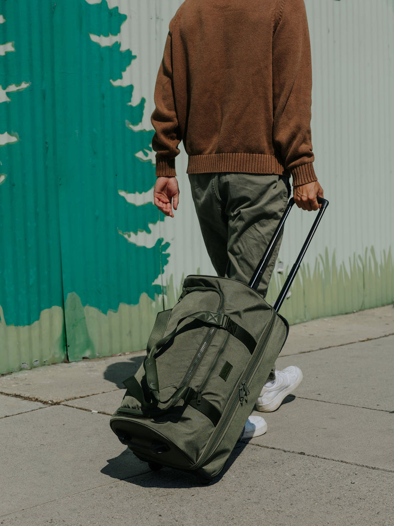 CALPAK Stevyn Rolling Duffle side view with top handle extended in moss