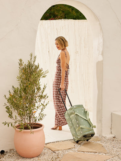 CALPAK Stevyn Rolling Duffel side view with top handle extended in daisy floral print; DSR2201-DAISY view 2