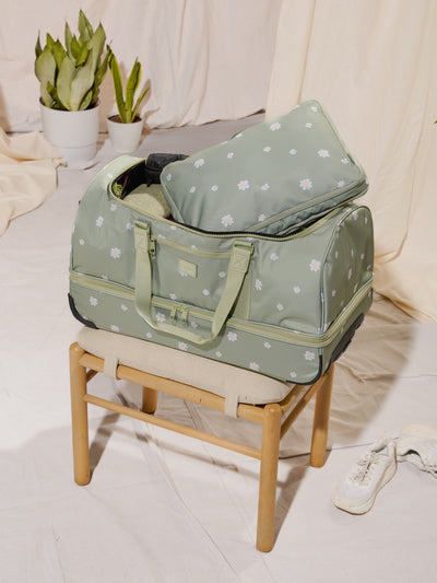 Packed CALPAK Stevyn Rolling Duffel bag with dual handles, wheels and shoe compartment in green floral daisy print