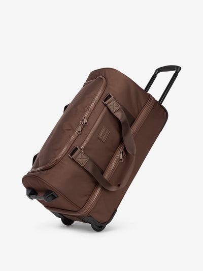 CALPAK Stevyn Rolling Duffel side view with top handle extended in walnut; DSR2201-WALNUT view 1