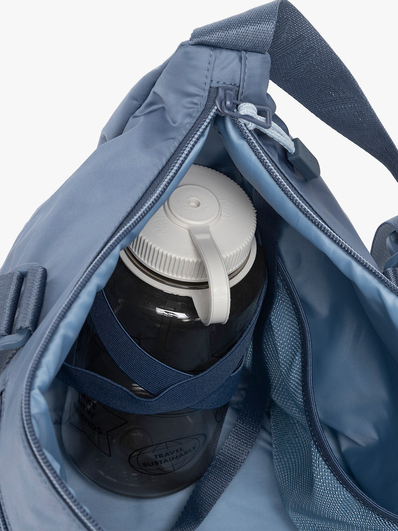 Water bottle in the CALPAK Fit Gym Duffel Bag in blue Indigo