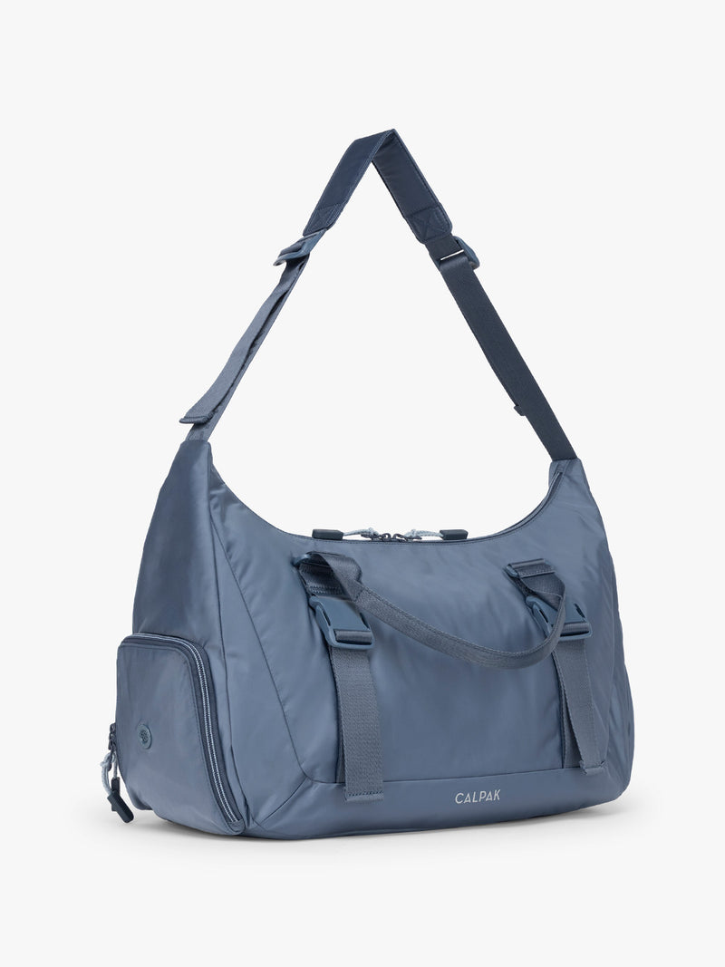 Side view of CALPAK Fit Gym Duffel Bag in blue Indigo