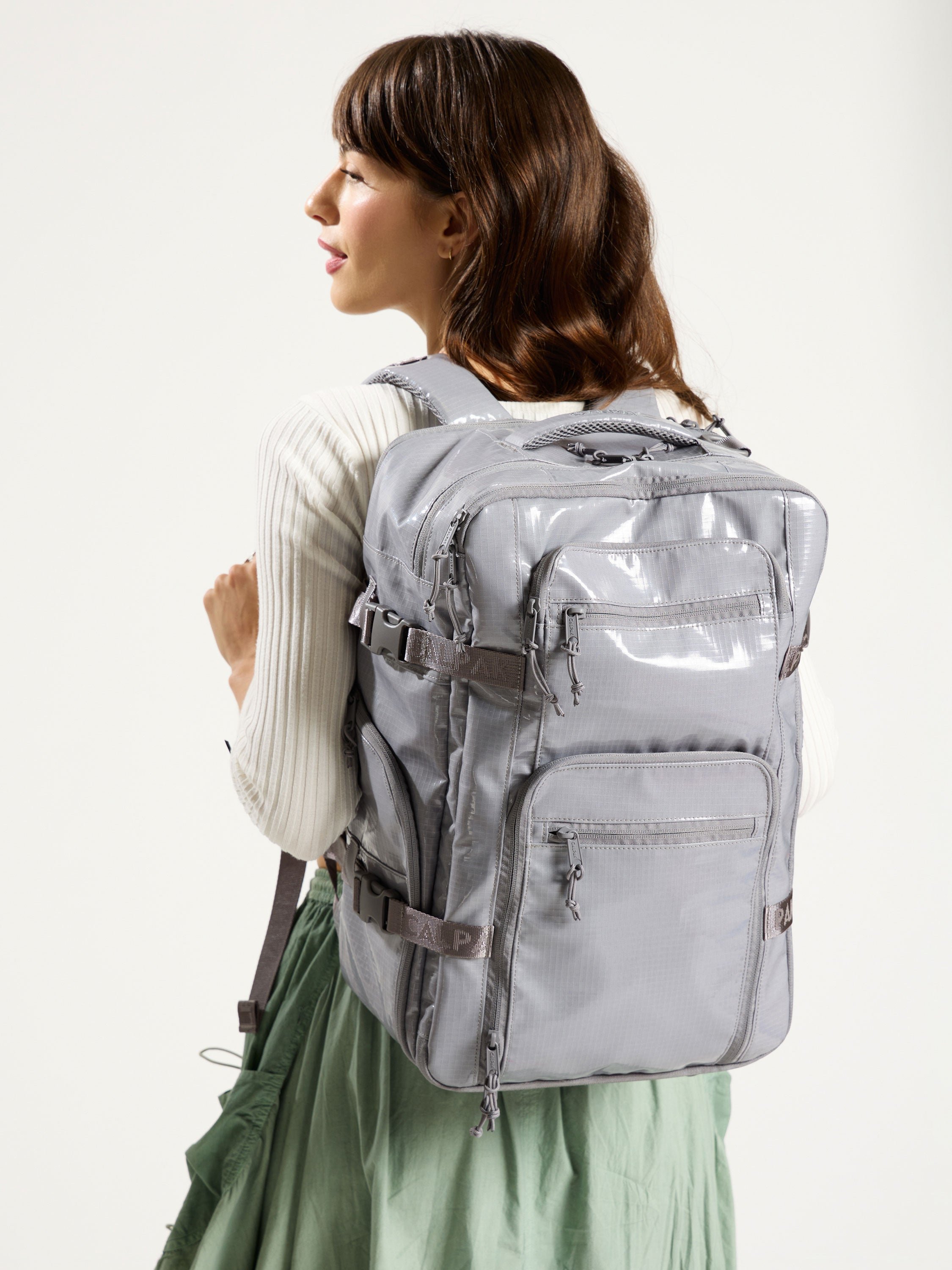Model wearing durable CALPAK 26L Laptop Backpack Duffel in gray; BPH2201-STORM