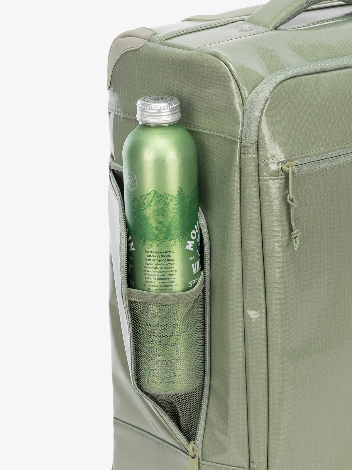 Studio product shot of side bottle holder pocket of CALPAK Terra 35L Carry-On luggage with soft shell and 360 spinner wheels in juniper green; LTR1020-JUNIPER