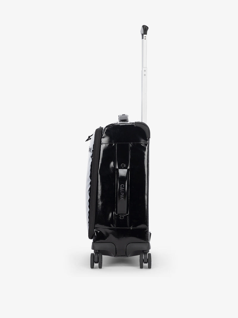 Studio product shot of side-facing CALPAK Terra 35L Carry-On luggage with soft shell and 360 spinner wheels in black