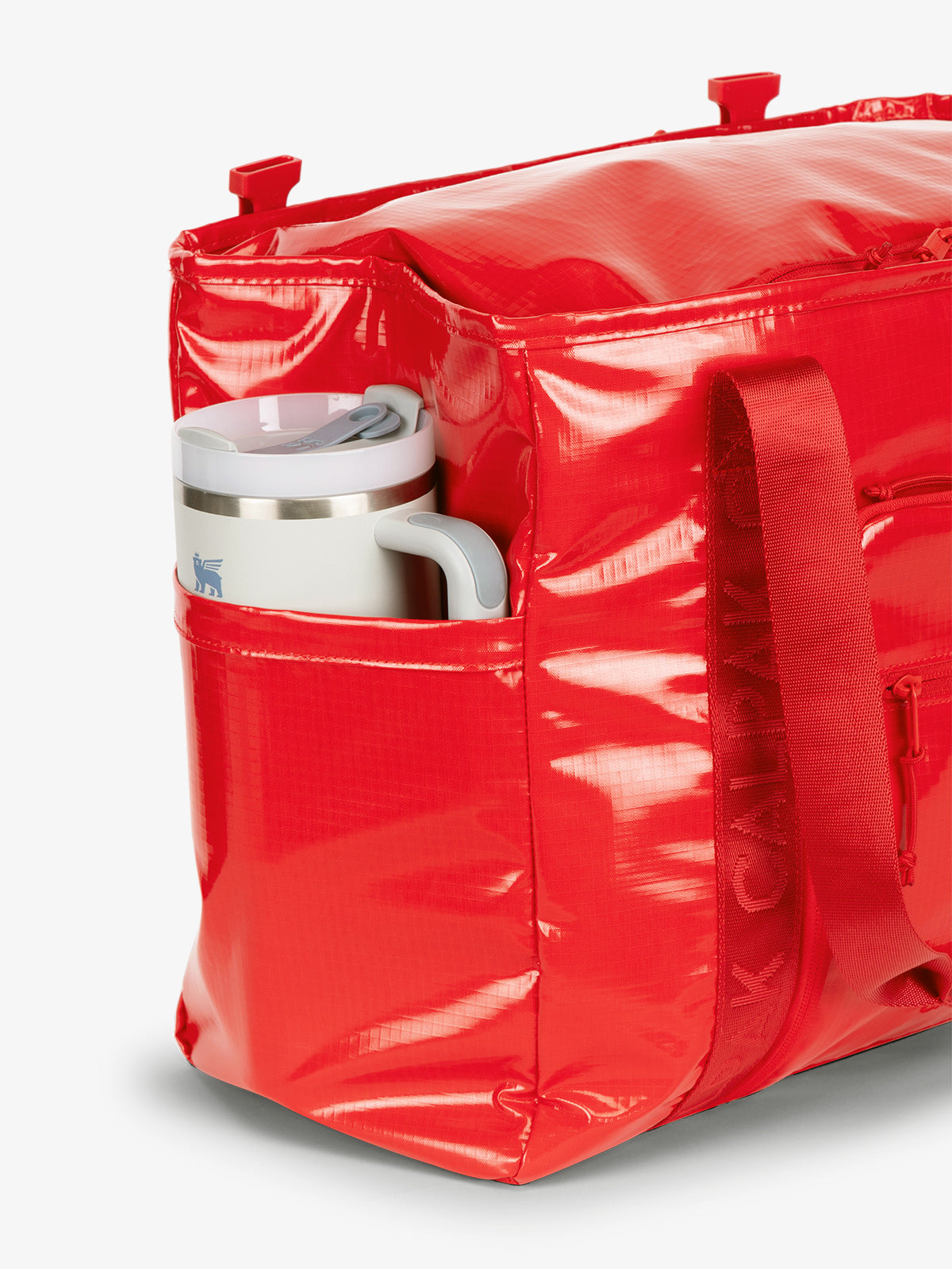 CALPAK Terra 35L Water Resistant Tote Bag in red with large side pocket holding a tumbler; TTO2401-FLAME
