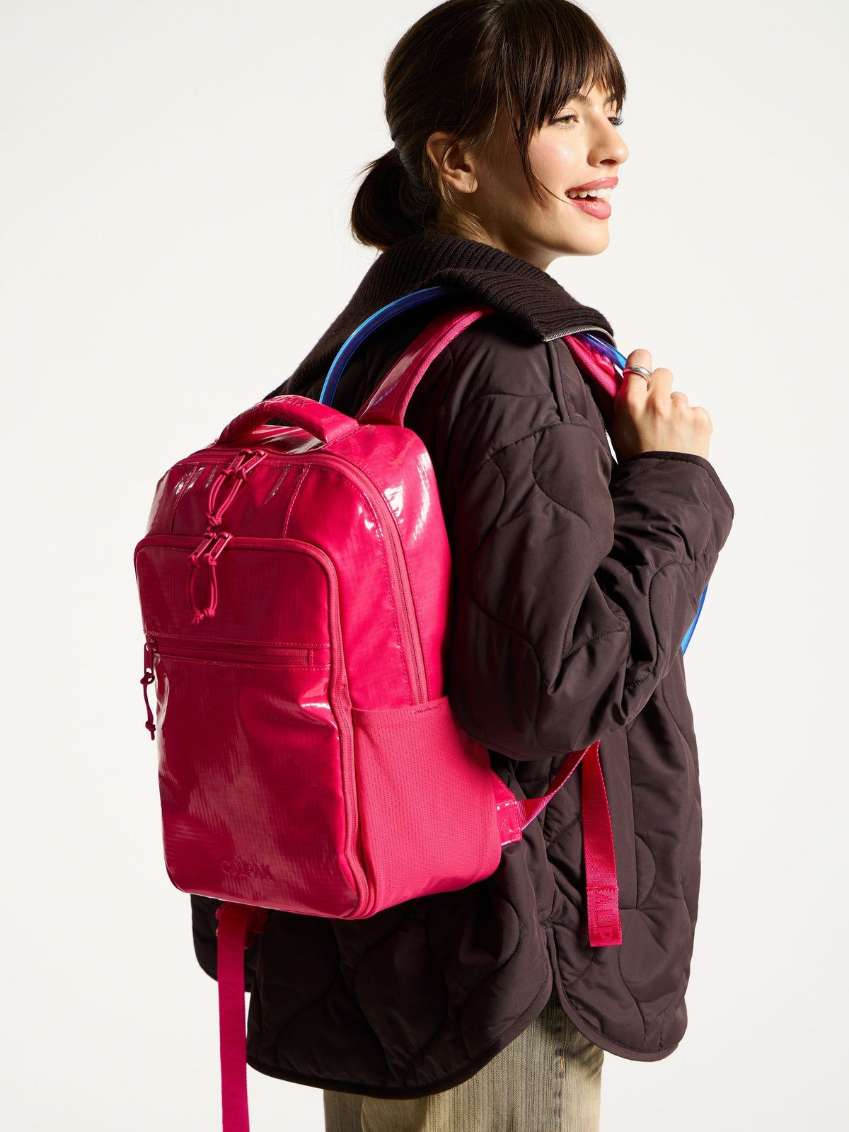 Model wearing CALPAK Hydration Backpack for hiking and camping; BPT2201-DRAGONFRUIT