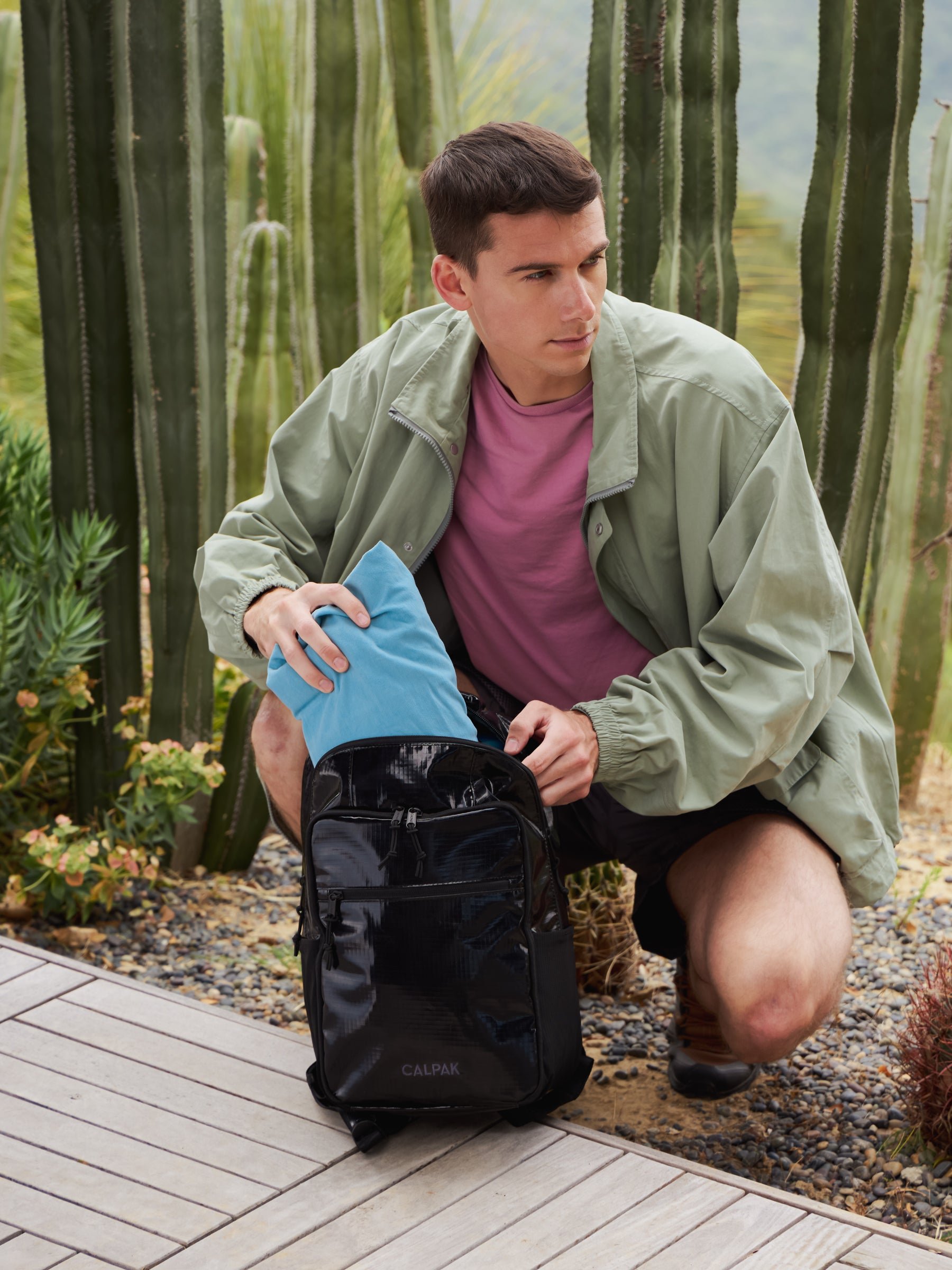 Model packing items in his black hydration backpack
