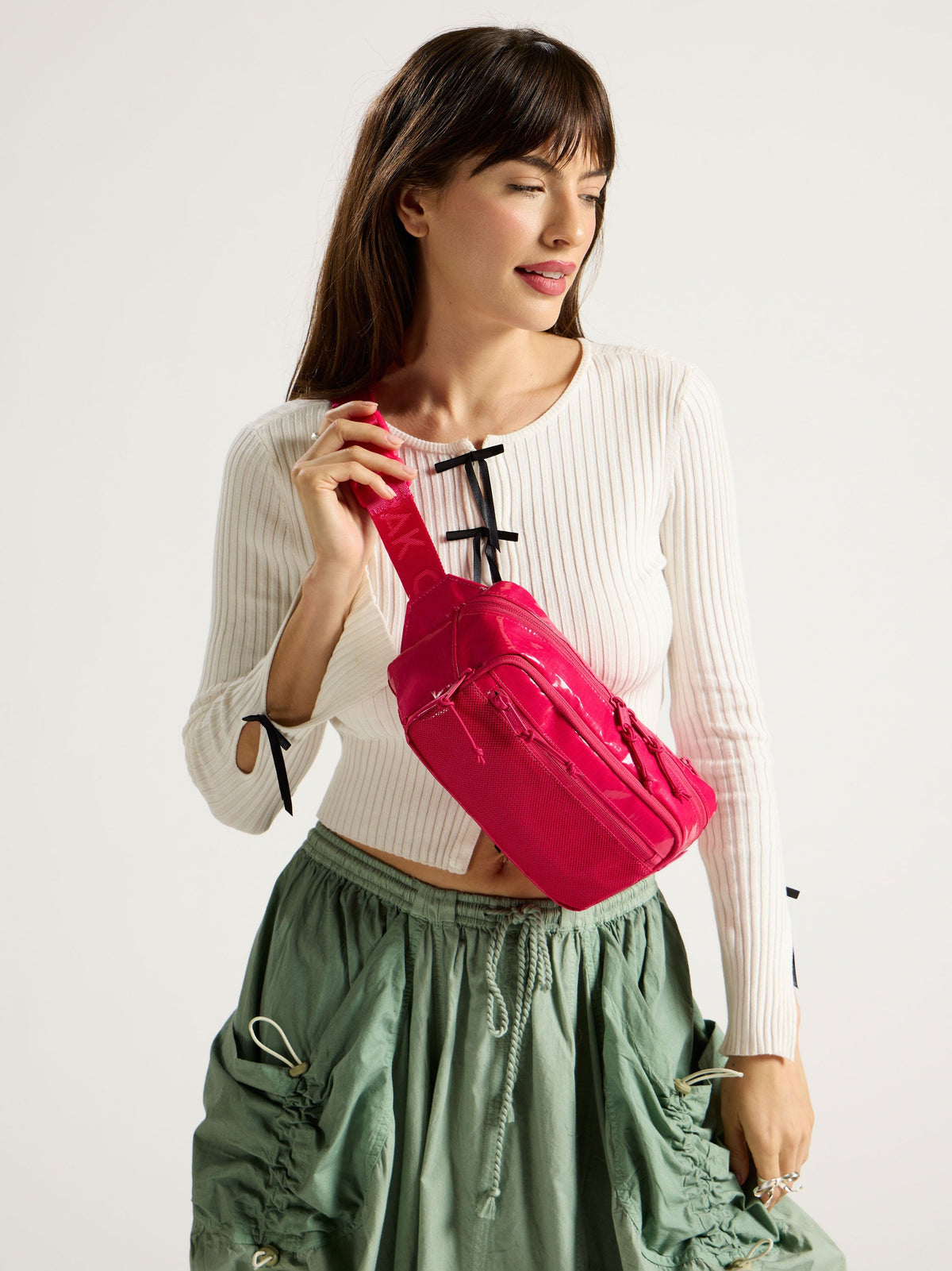 Model wearing CALPAK Terra Small Sling Bag in pink dragonfruit as crossbody bag; BBT2301-DRAGONFRUIT