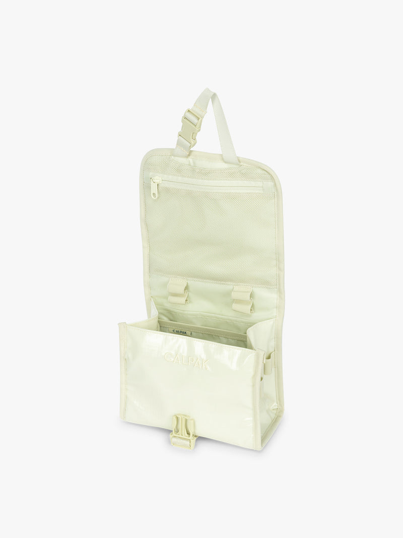 Opened CALPAK Terra Hanging Toiletry Bag in light green Celadon with front buckle